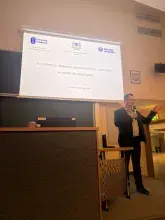 Zdjęcie przedstawiające prelegenta mówiącego do grupy na tle prezentacji