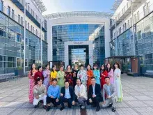 Zdjęcie przedstawiające grupę osób stojących w rzędzie przed budynkiem wydziału nauk społecznych